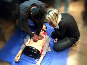 Cursist oefent reanimatie op een oefenpop tijdens de BHV cursus, met begeleiding van een instructeur